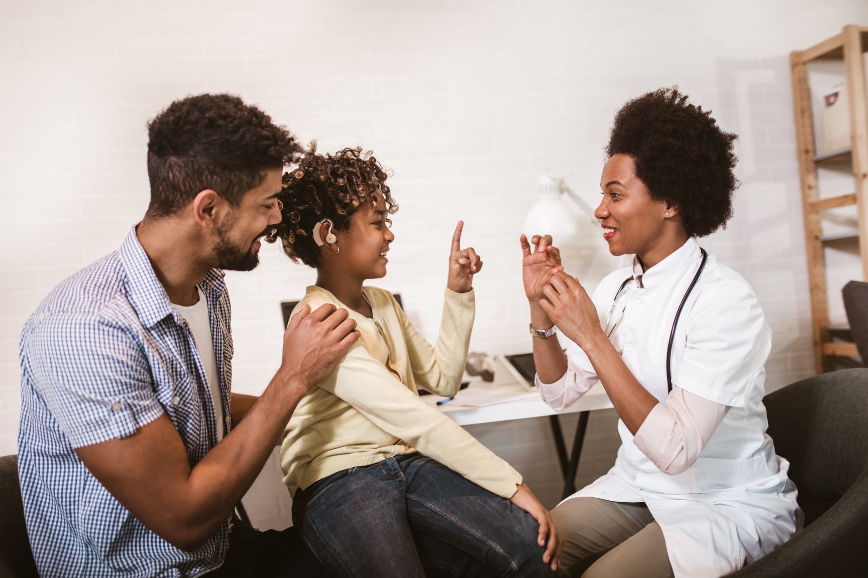 Smiling deaf girl learning sign language at doctor's office